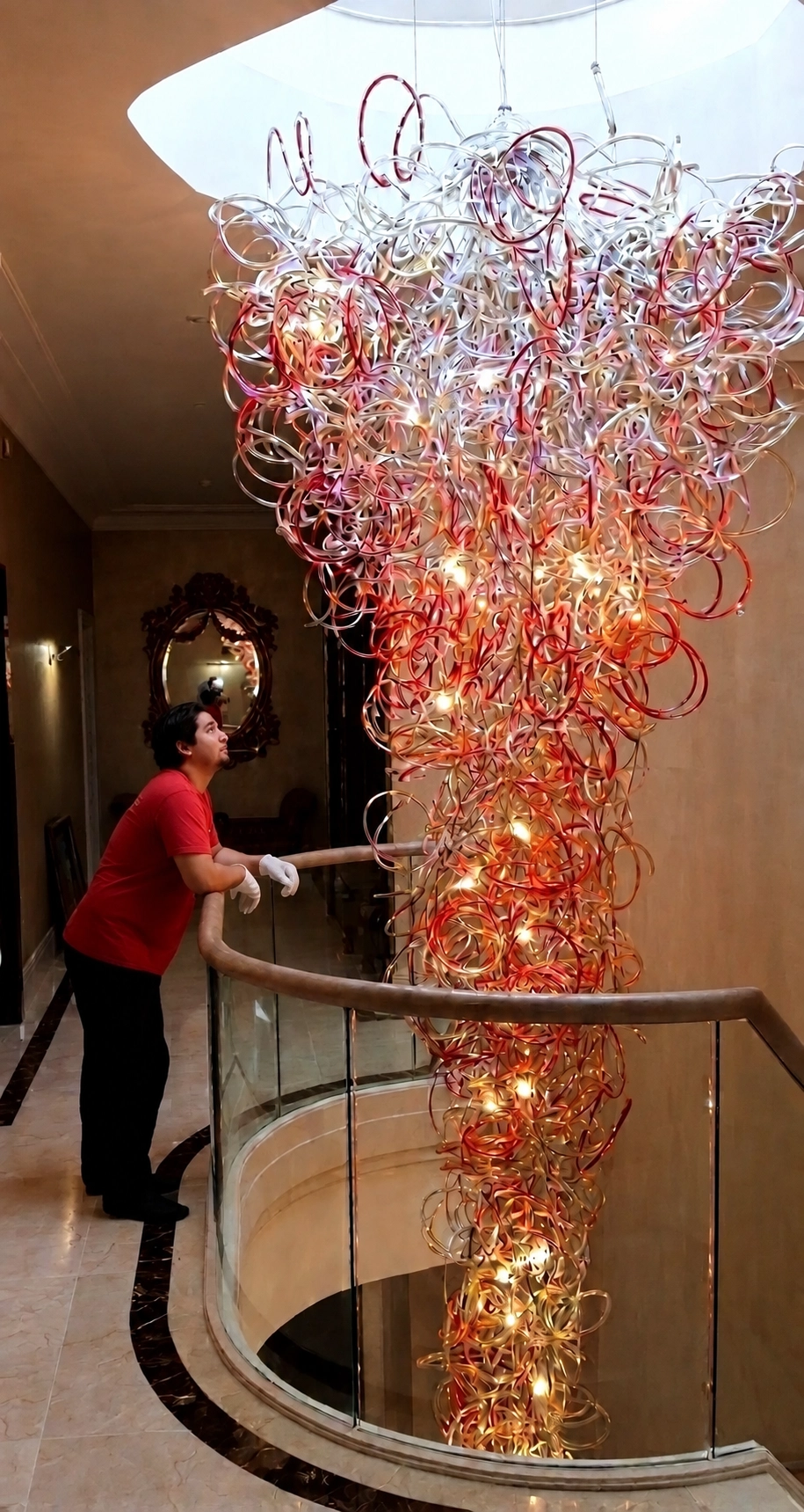 Chandelier specialist working beside a bespoke glass chandelier