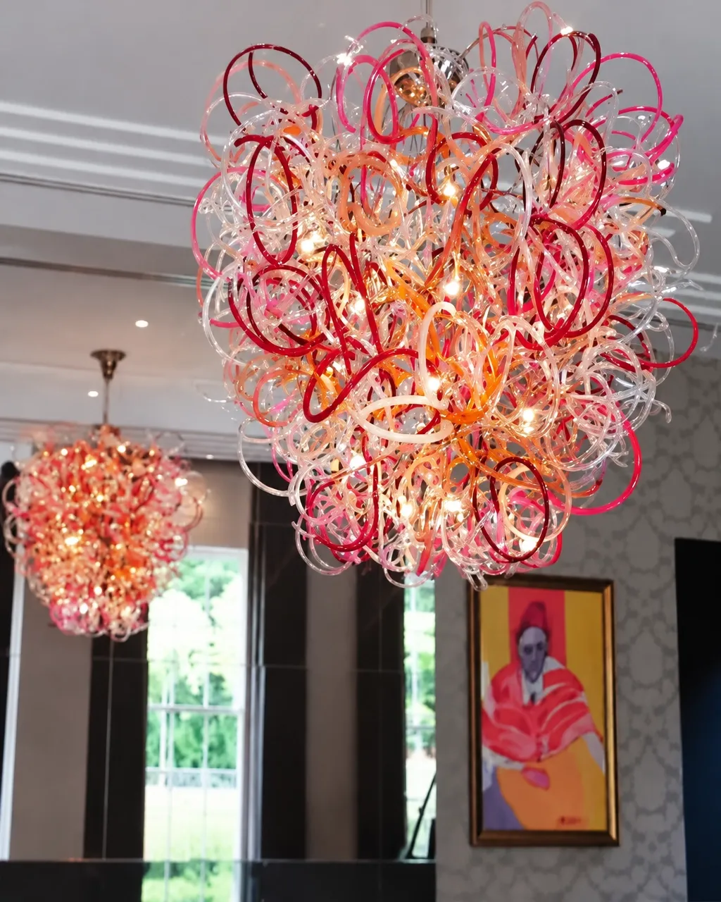 Red and clear glass-wire chandelier with sculptural loops and swirls